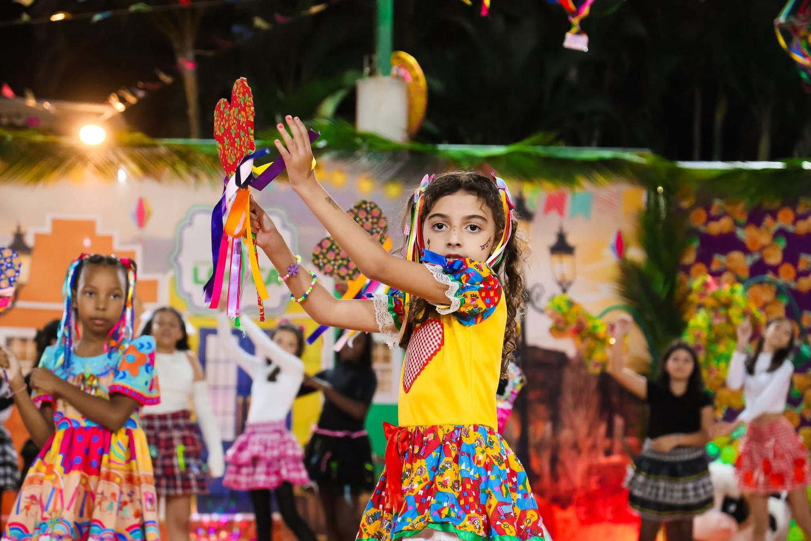 Aluna em apresentação de quadrilha junina com fitas coloridas