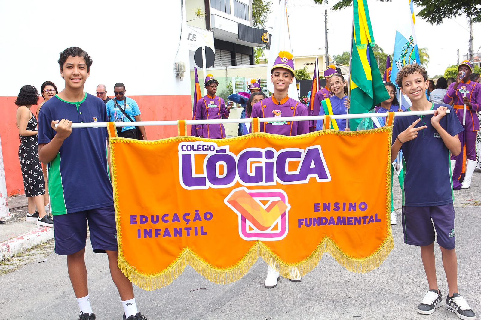 Alunos do Colégio Lógica posando com o estandarte da escola